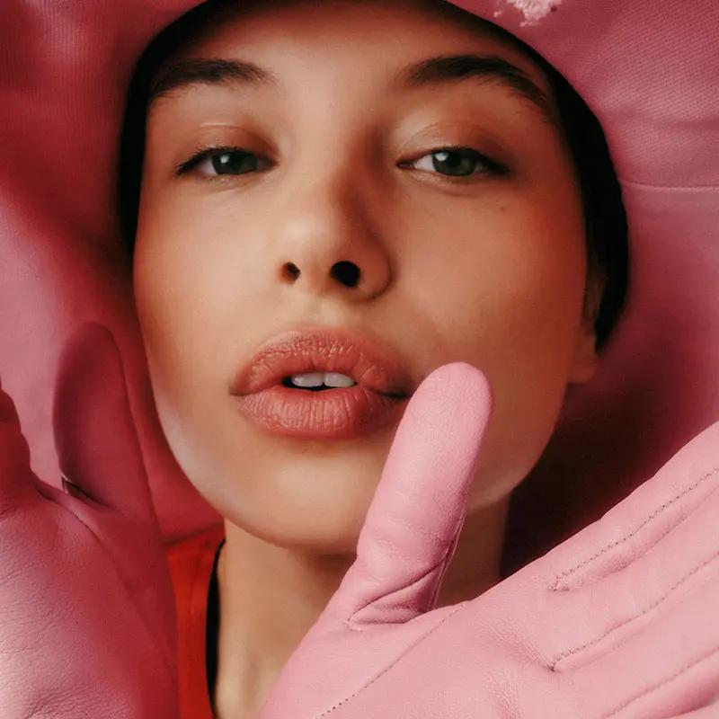 Woman wearing big pink hat and pink gloves